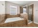 Beautiful bathroom with soaking tub, glass-enclosed shower, and tiled surround at 5911 Grassy Point Rd, Winter Garden, FL 34787