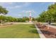 Community lawn and clock tower lined with trees and benches at 5911 Grassy Point Rd, Winter Garden, FL 34787