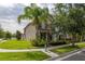 Inviting two-story home with lush green lawn, mature palm tree, and well-maintained landscaping for great curb appeal at 5911 Grassy Point Rd, Winter Garden, FL 34787