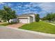 View of the home and detached garage with the red brick paver driveway and green lawn at 5911 Grassy Point Rd, Winter Garden, FL 34787