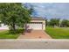 Exterior of the detached garage showing its door, brick paver driveway and the surrounding landscaping at 5911 Grassy Point Rd, Winter Garden, FL 34787