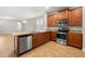 Modern kitchen with stainless steel appliances, granite countertops, wooden cabinets, and tile flooring at 5911 Grassy Point Rd, Winter Garden, FL 34787