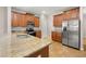 Well-equipped kitchen featuring stainless steel appliances, granite countertops, and warm wood cabinetry, blending style and function at 5911 Grassy Point Rd, Winter Garden, FL 34787