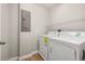 Bright laundry room with washer, dryer, and overhead wire shelving at 5911 Grassy Point Rd, Winter Garden, FL 34787