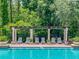 Inviting pool area featuring sun loungers under a pergola, perfect for relaxing poolside in a lush, green setting at 5911 Grassy Point Rd, Winter Garden, FL 34787