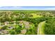 Overhead aerial view displays the neighborhood and home nestled amongst trees and a community green space at 6234 Tremayne Dr, Mount Dora, FL 32757