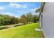 Expansive backyard featuring lush green grass and bordering a road, offering outdoor space at 6234 Tremayne Dr, Mount Dora, FL 32757