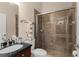 Bathroom features a tiled walk-in shower, vanity with black countertop and neutral walls at 6234 Tremayne Dr, Mount Dora, FL 32757