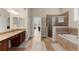 The bathroom features a soaking tub, tiled shower, double vanity, and neutral color palette at 6234 Tremayne Dr, Mount Dora, FL 32757