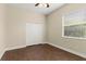 Bedroom features wood-look tile, a ceiling fan, closet, and large window for natural light at 6234 Tremayne Dr, Mount Dora, FL 32757