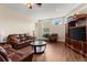 Comfortable living area with hardwood floors, a leather sofa set, and a large entertainment center at 6234 Tremayne Dr, Mount Dora, FL 32757