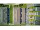 Aerial view of townhome rooftops, paved parking area, sidewalk, and manicured green space at 625 Dogfish Ln, Debary, FL 32713