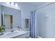 Bathroom features a modern vanity with a sink, quartz counters, and shower with a blue patterned curtain at 625 Dogfish Ln, Debary, FL 32713