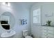Well-lit half bathroom with a vanity, decorative mirror, and elegant wallpaper at 625 Dogfish Ln, Debary, FL 32713