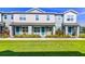 Charming two-story townhome featuring a quaint front porch, blue door, and landscaped front yard at 625 Dogfish Ln, Debary, FL 32713