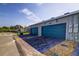 Row of garages with blue doors and brick-paved driveways providing convenient parking at 625 Dogfish Ln, Debary, FL 32713