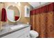 Well-lit bathroom with a granite countertop vanity and patterned shower curtain at 752 Howland Ln # 114, Altamonte Springs, FL 32701