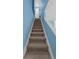Carpeted staircase leading to the second floor, with a bright blue accent wall at 752 Howland Ln # 114, Altamonte Springs, FL 32701