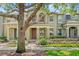 A cozy townhouse with a well-maintained front yard and tree at 7715 Anselmo Ln, Windermere, FL 34786