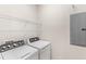 Efficient laundry room featuring a washer, dryer, and wire shelving for storage at 7715 Anselmo Ln, Windermere, FL 34786