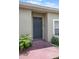View of the home's front door with a small plant, peephole, and security camera at 8141 Golden Chickasaw Cir, Orlando, FL 32825