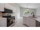 Bright kitchen features white cabinets, black appliances, and tiled floor at 8141 Golden Chickasaw Cir, Orlando, FL 32825
