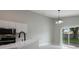 Bright kitchen features white cabinets, black appliances, and sliding glass doors to the backyard at 8141 Golden Chickasaw Cir, Orlando, FL 32825