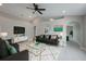 Modern living room with gray walls, ceiling fan, sleek furniture, and bright white rug with gold accents at 8141 Golden Chickasaw Cir, Orlando, FL 32825