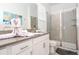 Well-lit bathroom featuring a white vanity, gray countertops, decorative towel swans, and a glass-enclosed shower at 8964 Takeaway Way, Davenport, FL 33896