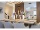 A formal dining room displays a modern chandelier, wood paneling and a table set for a dinner party at 8964 Takeaway Way, Davenport, FL 33896