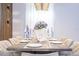 A formal dining room is decorated with a rustic wood table, upholstered chairs and a dramatic lighting fixture at 8964 Takeaway Way, Davenport, FL 33896