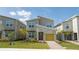 Modern two-story home with a yellow garage door, stone accents, and landscaped yard at 8964 Takeaway Way, Davenport, FL 33896