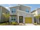 Modern two-story home with a yellow garage door, stone accents, and landscaped yard at 8964 Takeaway Way, Davenport, FL 33896