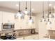 Kitchen featuring stainless steel appliances, a large island, and globe pendant lighting at 8964 Takeaway Way, Davenport, FL 33896