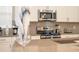 Modern kitchen with stainless steel appliances, neutral cabinets, gray backsplash and solid surface counters at 8964 Takeaway Way, Davenport, FL 33896