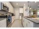 Well-lit kitchen with stainless steel appliances, gray countertops, and stylish pendant lights at 8964 Takeaway Way, Davenport, FL 33896