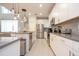 A bright, modern kitchen features stainless steel appliances, white cabinets, and light gray backsplash at 8964 Takeaway Way, Davenport, FL 33896