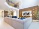 A modern living room features a soaring ceiling, a large gray sectional, with two-story wood paneled accent wall at 8964 Takeaway Way, Davenport, FL 33896