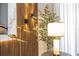 A modern living room is decorated with a ficus tree, a modern light fixture, and paneled accent wall at 8964 Takeaway Way, Davenport, FL 33896