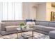 A spacious living room features a large sectional sofa, round table, and neutral paint for a bright open space at 8964 Takeaway Way, Davenport, FL 33896