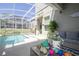 Inviting covered patio is perfect for outdoor gatherings with a comfortable seating area and views of the screened-in pool at 8964 Takeaway Way, Davenport, FL 33896