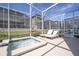 Stylish screened-in pool features a bubbling spa and poolside lounge chairs for ultimate relaxation at 8964 Takeaway Way, Davenport, FL 33896