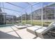 Inviting screened-in pool area features a spa, modern furniture, and plenty of space for relaxation and entertainment at 8964 Takeaway Way, Davenport, FL 33896