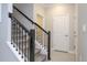 Carpeted stairs with decorative iron railing leads to the upper level of this home with neutral walls at 8964 Takeaway Way, Davenport, FL 33896