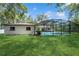 Backyard with large lawn featuring screened in pool attached to a home at 898 Shed St, Oviedo, FL 32765