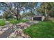Charming single-story home boasts lush lawn, mature trees, and a long driveway leading to an attached two-car garage at 898 Shed St, Oviedo, FL 32765