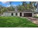 A well-manicured lawn enhances this charming single-story home with a dark brown garage door and trimmed landscaping at 898 Shed St, Oviedo, FL 32765