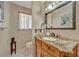 Charming half bathroom featuring a marble countertop, decorative mirror, and wallpaper at 1115 Lake Francis Dr, Apopka, FL 32712