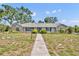 Charming single-story home with stone accents, mature trees, and walkway leading to the front entrance at 1115 Lake Francis Dr, Apopka, FL 32712