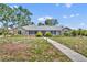 Charming single-story home with stone accents, mature trees, and walkway leading to the front entrance at 1115 Lake Francis Dr, Apopka, FL 32712